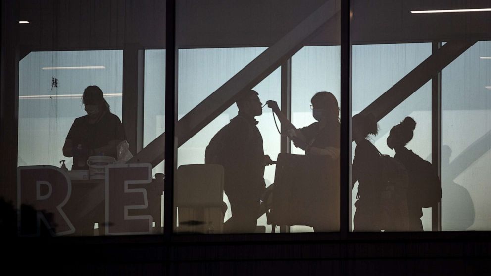 PHOTO: Hospital workers check temperatures of coworkers at a pedestrian walkway at Dell Seton Medical Center at the University of Texas in Austin, Texas, April 13, 2020.