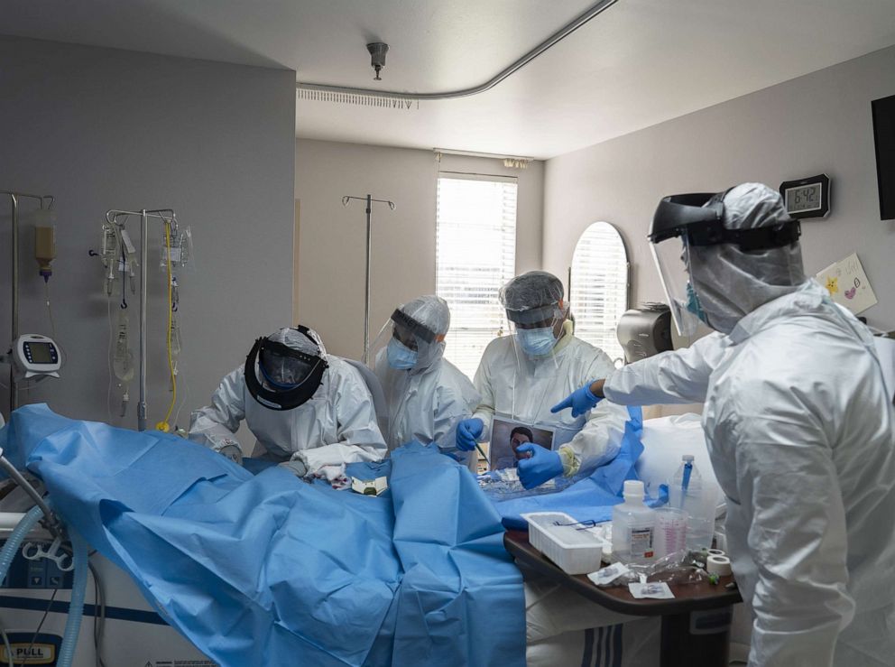 PHOTO: Doctors and nurses wearing protective gear treat a patient in the Covid-19 intensive care unit (ICU) at the United Memorial Medical Center (UMMC) in Houston, Texas on June 29, 2020.