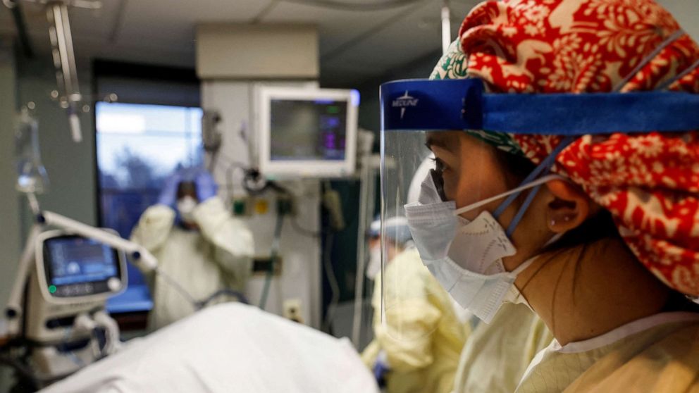 PHOTO: Sammy Taylor, a registered nurse at Western Reserve Hospital, works with other medical staff treating a COVID-19 patient in their isolation room on the Intensive Care Unit (ICU) at Western Reserve Hospital in Cuyahoga Falls, Ohio, Jan. 4, 2022. 