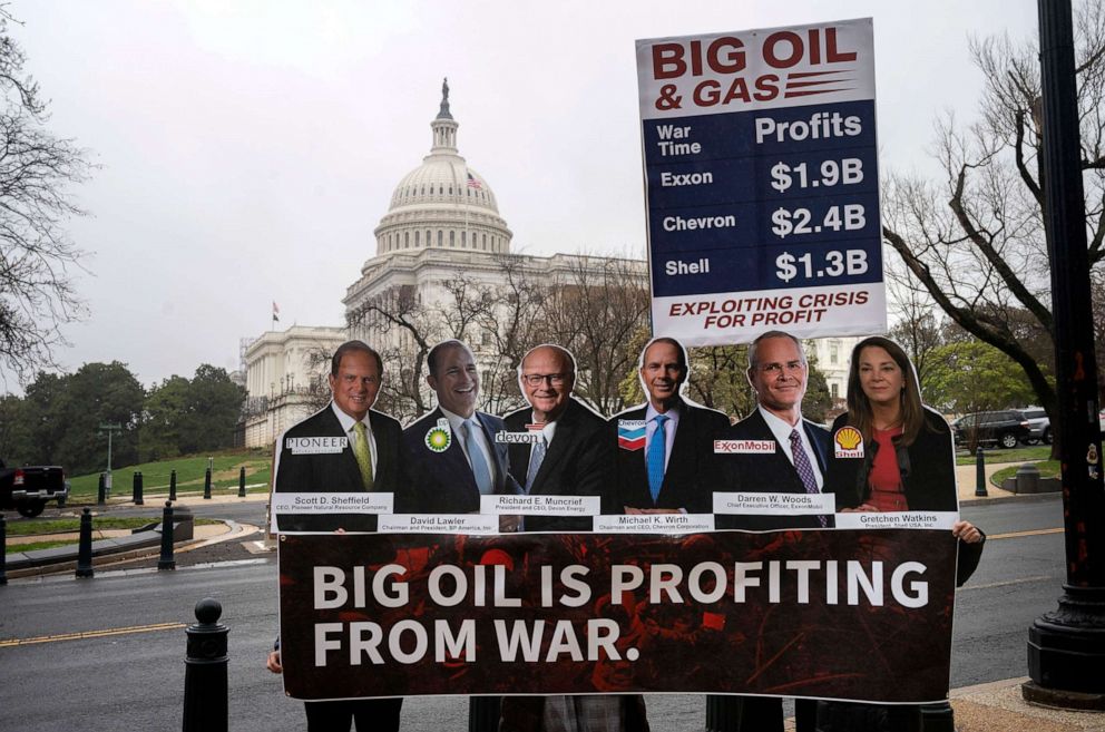 PHOTO: Protesters stand outside the Rayburn House Office Building holding a signing reading "Big Oil is Profiteering from War" before the start of a House Energy and Commerce Committee hearing in Washington, April 6, 2022.