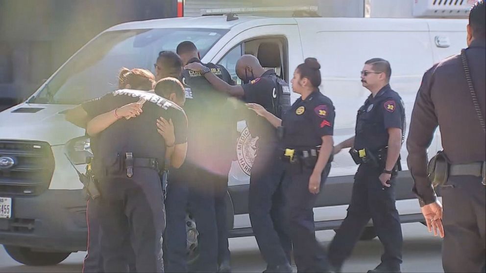 PHOTO: Members of law enforcement embrace after a Harris County Constable Deputy was shot to death in Houston, Oct. 16, 2021.