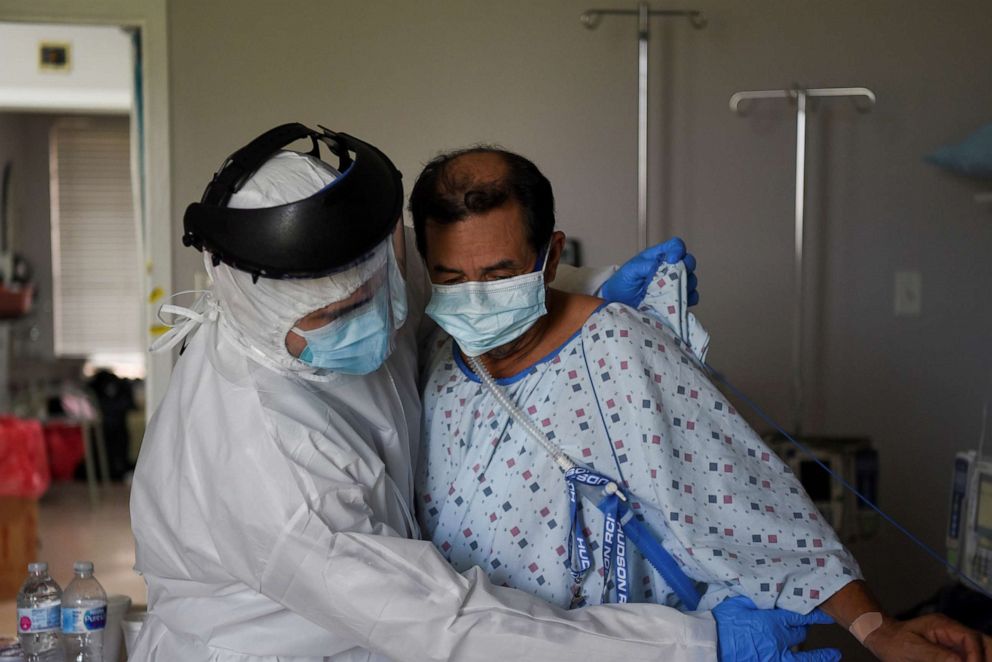 PHOTO: Fernando Olvera, 26, a medical school student, helps Efrain Guevara, 63, who has been hospitalised with COVID-19, get up from his hospital bed, at United Memorial Medical Center (UMMC) in Houston, Texas, July 17, 2020.