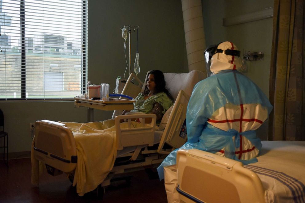 PHOTO: Larissa Raudales, 18, who has been hospitalised with COVID-19, sits on a hospital bed as she is checked on by a medical student at United Memorial Medical Center (UMMC) in Houston, Texas, July 25, 2020.