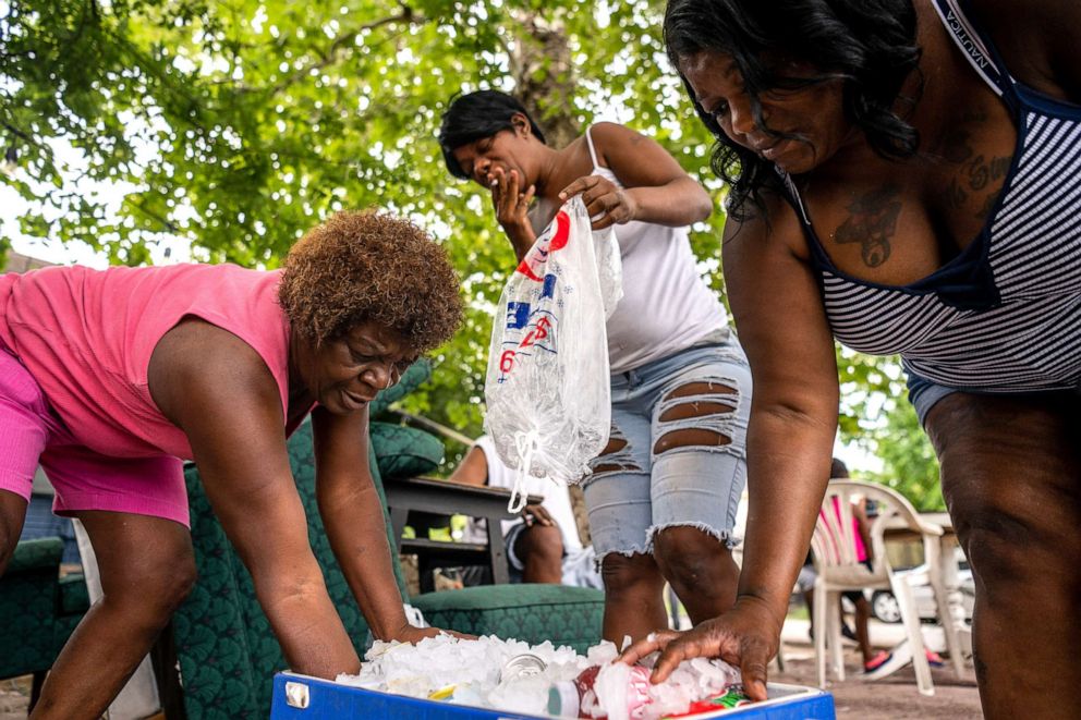 PHOTO: A person fills an ice chest with neighbors outside of their family's home on July 21, 2022 in Houston.