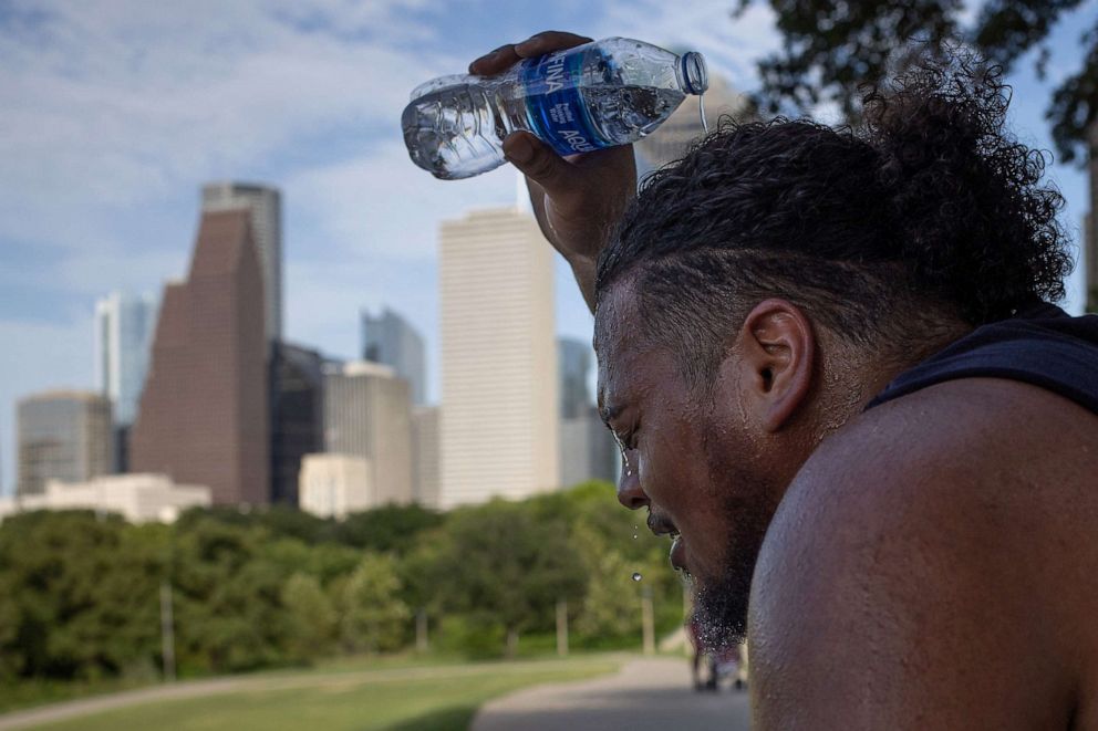 PHOTO: Travis Santiago cools off with water after working out at Eleanor Tinsley Park as temperatures hit 100 degrees Fahrenheit in Houston, July 12, 2023.