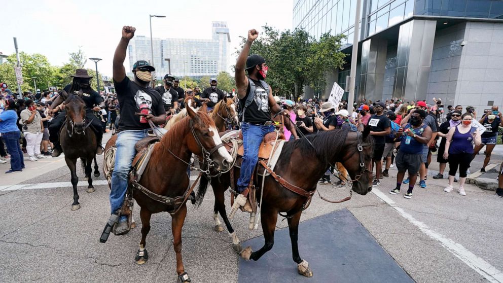 PHOTO: People march and ride horses to protest the death of George Floyd in Houston on Tuesday, June 2, 2020.