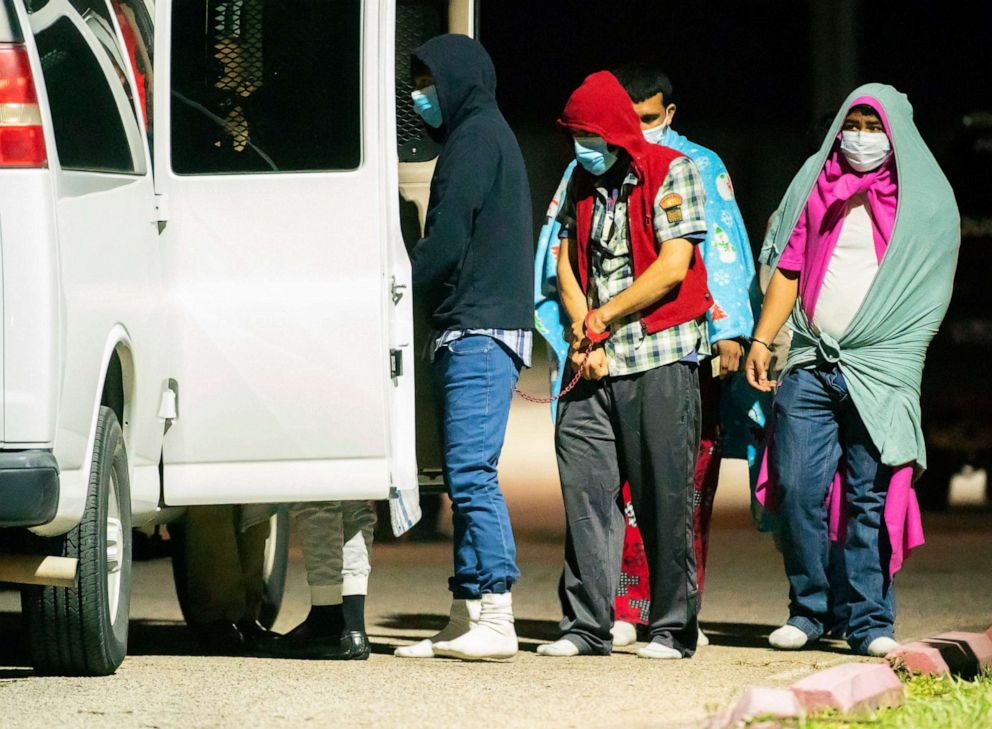 PHOTO: People are handcuffed together in pairs and loaded into vans as police investigate a possible human smuggling operation, early in the morning on Dec. 4, 2020, in Houston.