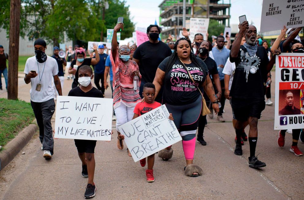 PHOTO: People hold signs as they protest and mourn the death of George Floyd in Houston, May 30, 2020.