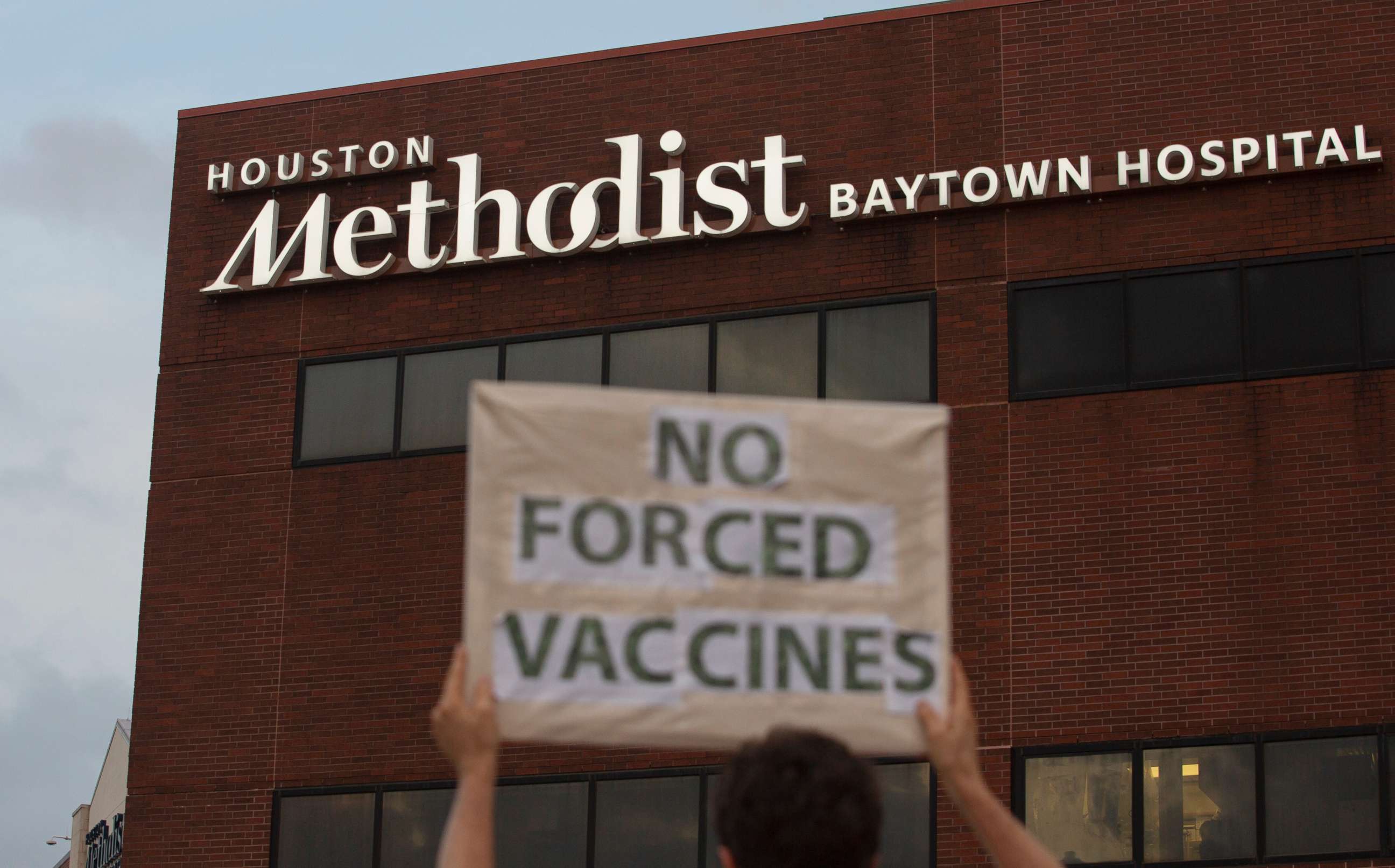 PHOTO: People hold signs to protest Houston Methodist Hospital system's rule of firing any employee who is not immunized by Monday, June 7, 2021, at Houston Methodist Baytown Hospital in Baytown, Texas.