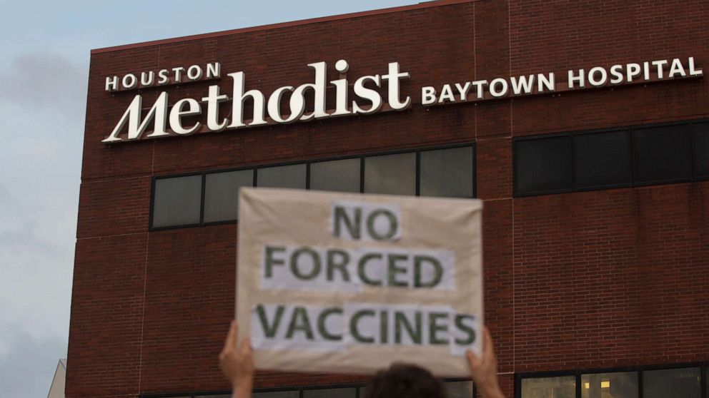 PHOTO: People hold signs to protest Houston Methodist Hospital system's rule of firing any employee who is not immunized by Monday, June 7, 2021, at Houston Methodist Baytown Hospital in Baytown, Texas.