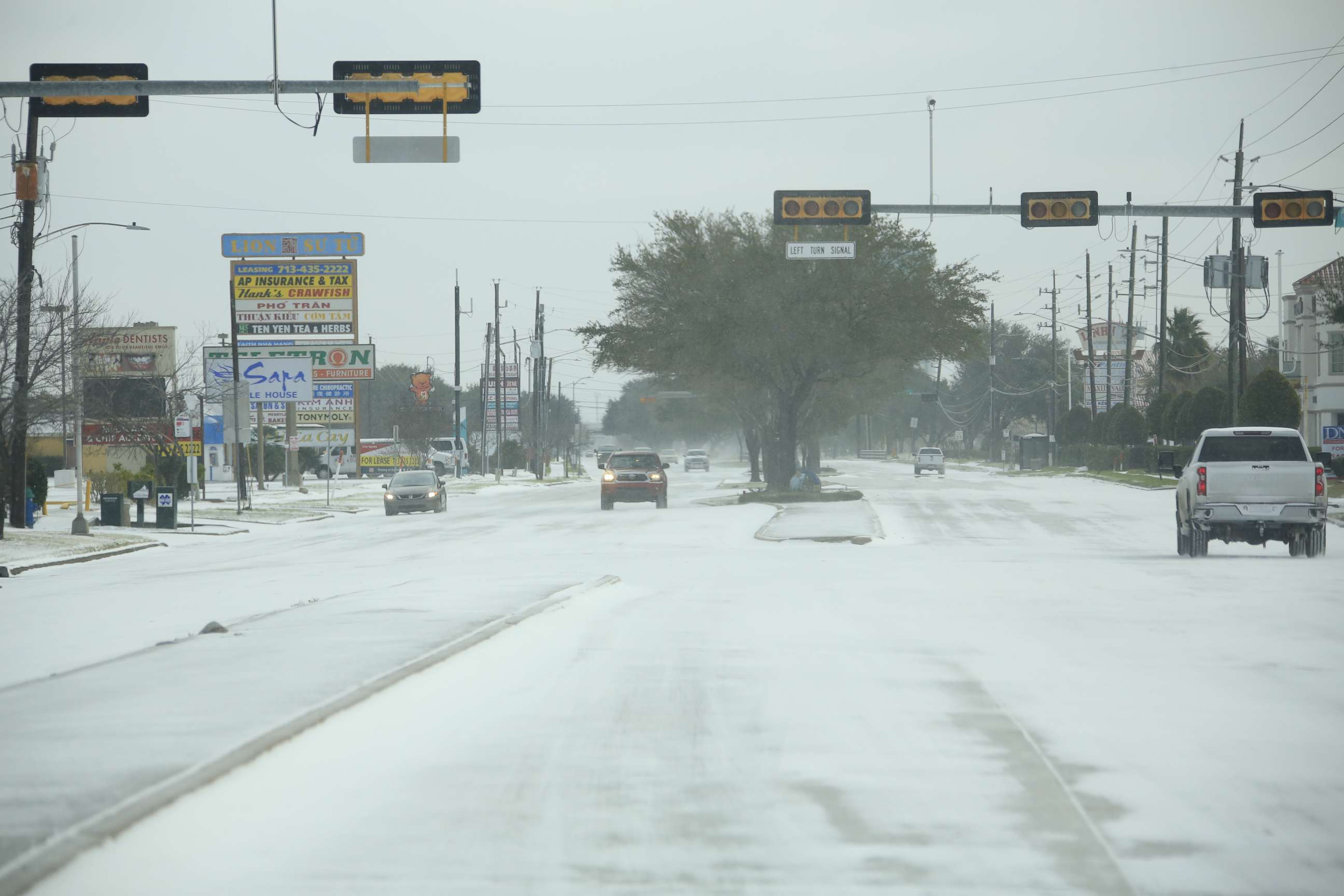 PHOTO: Vehicles move past street lights without power during a winter storm in Houston, Feb. 15, 2021.
