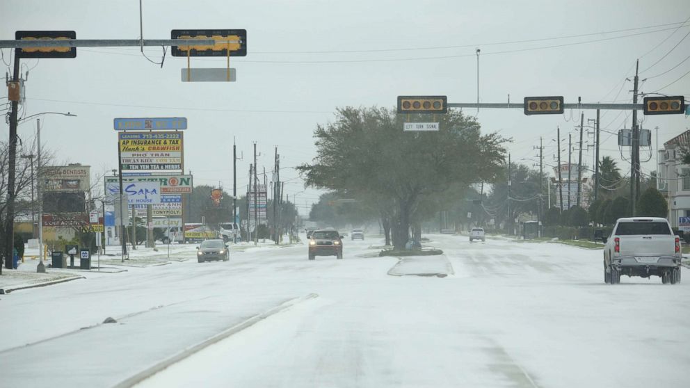 PHOTO: Vehicles move past street lights without power during a winter storm in Houston, Feb. 15, 2021.