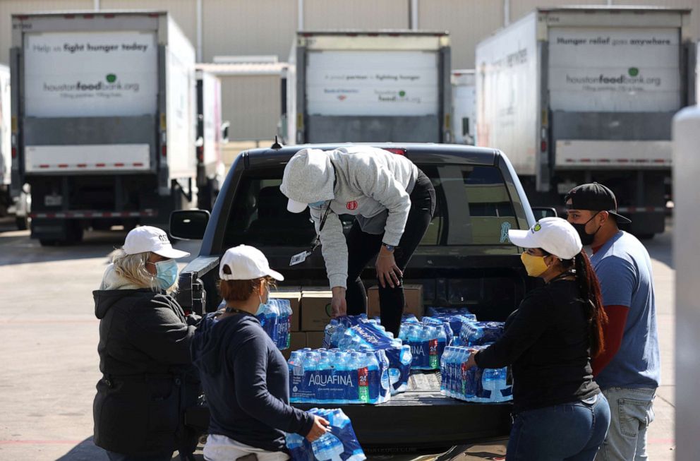 PHOTO: Volunteers load cases of water and emergency food boxes into a truck at the Houston Food Bank on Feb. 20, 2021 in Houston, Texas.