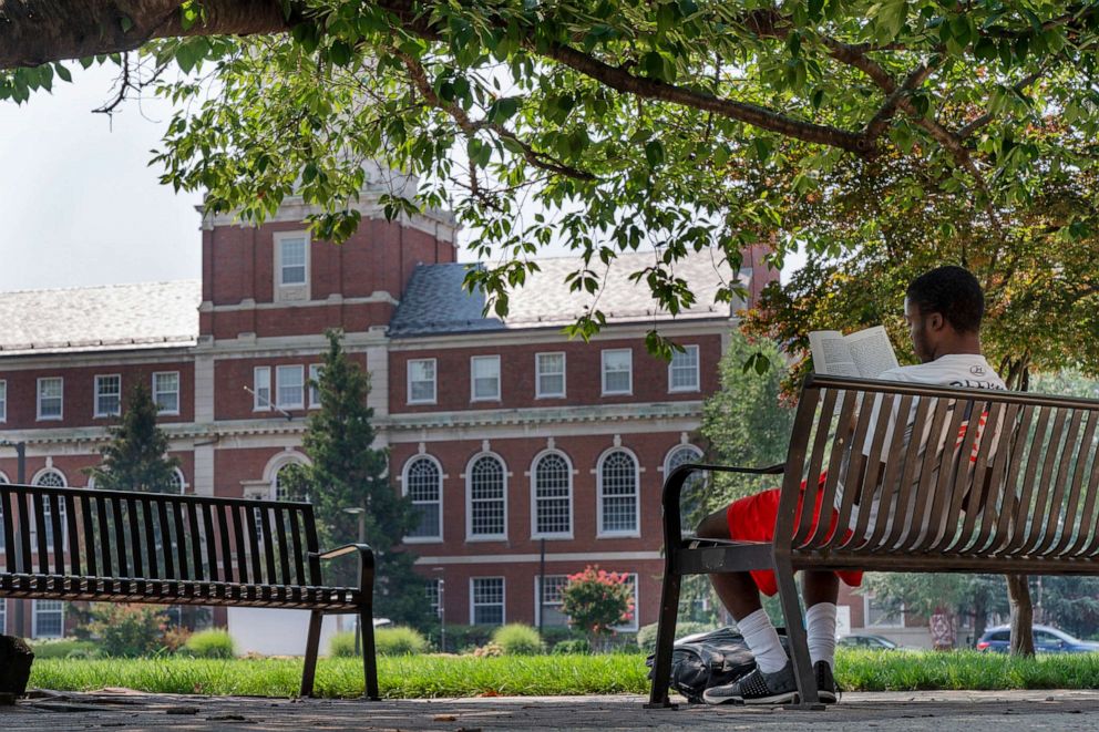 PHOTO: With the Founders Library in the background, a young man reads on Howard University campus, July 6, 2021, in Washington.