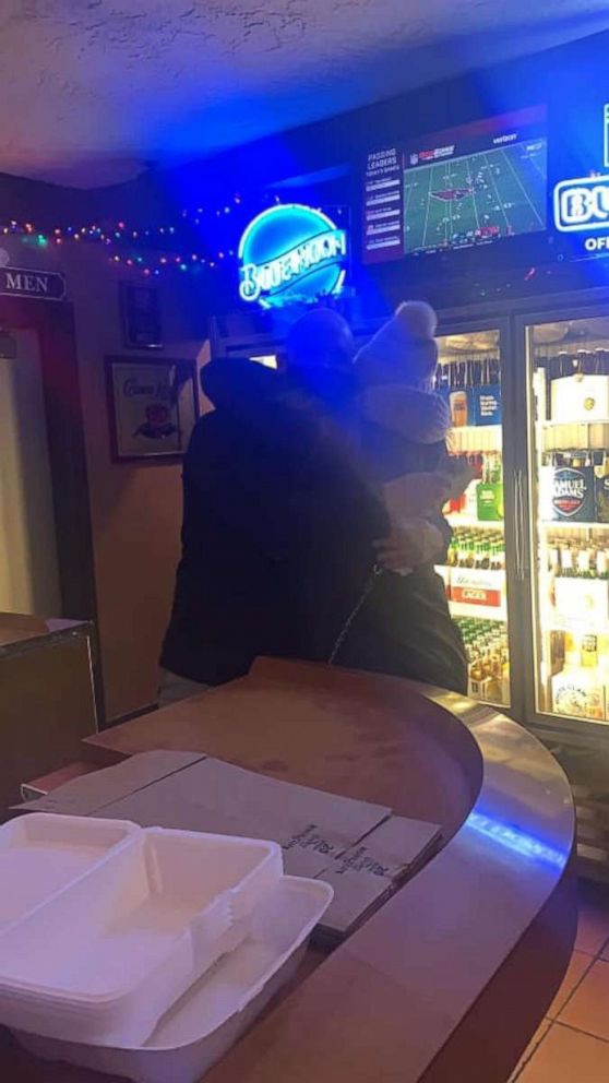 A restaurant worker hugs Brittany Scharr.