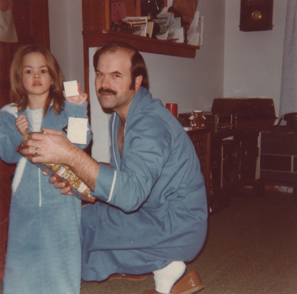A young Kerri Rawson is seen here with her father, Dennis Rader, opening a Christmas present in 1981. 