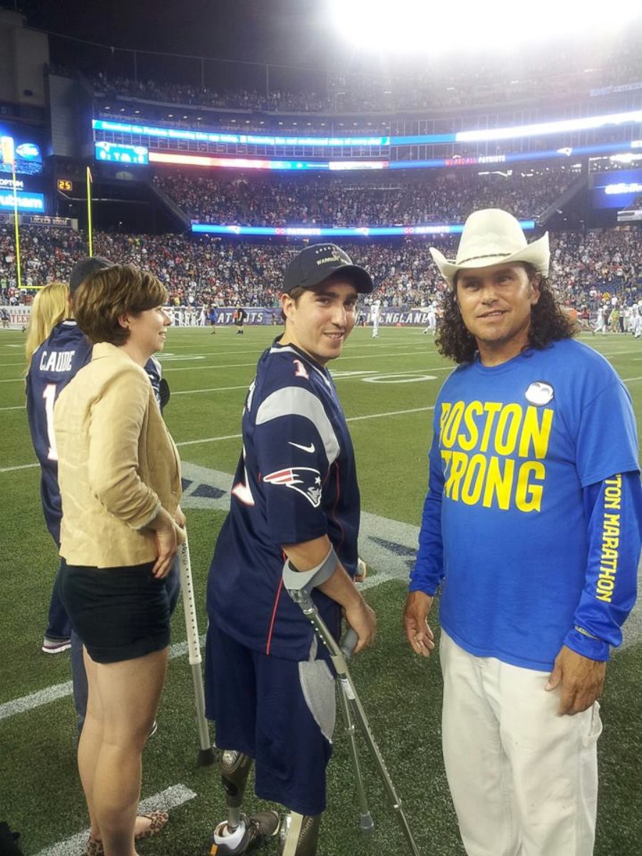 PHOTO: Carlos Arredondo, right, and Jeff Bauman, center, are pictured at a Patriots game against the Jets in Foxborough, Mass.