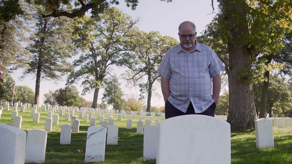 Evan Williams stands in front of his sister Margaret Williams' grave.