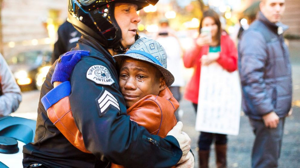 Police Sgt. Bret Barnum hugs 12-year-old Devonte Hart during a demonstration in Portland, Ore. calling for police reform after the Ferguson grand jury decision on Nov. 25, 2014.