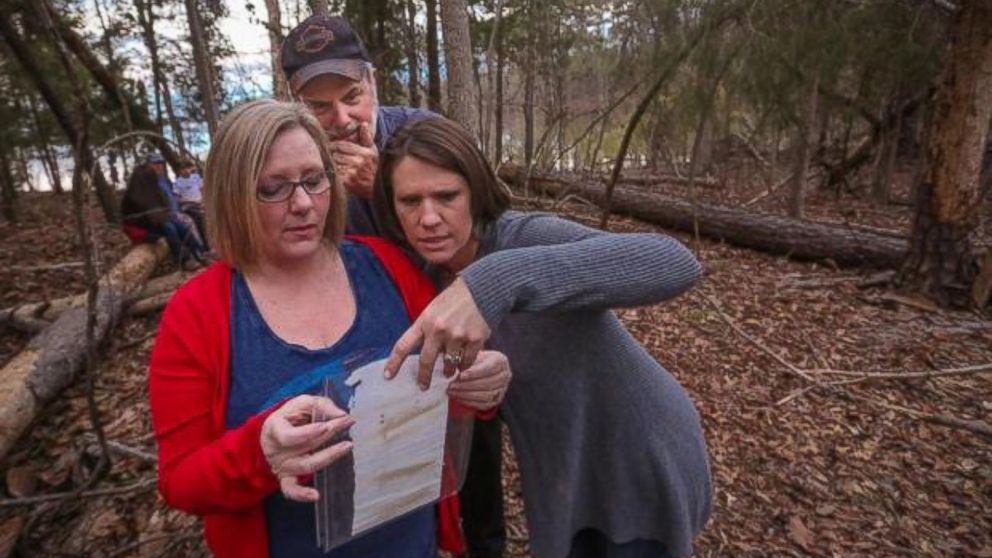 Diane Bryant, left, reads a note she put in a bottle 45 years ago to her then boyfriend, Mike Rogers, center, as Viki Garrick watches. Garrick’s son, Nolan, Rogers’ grandson, found it. 