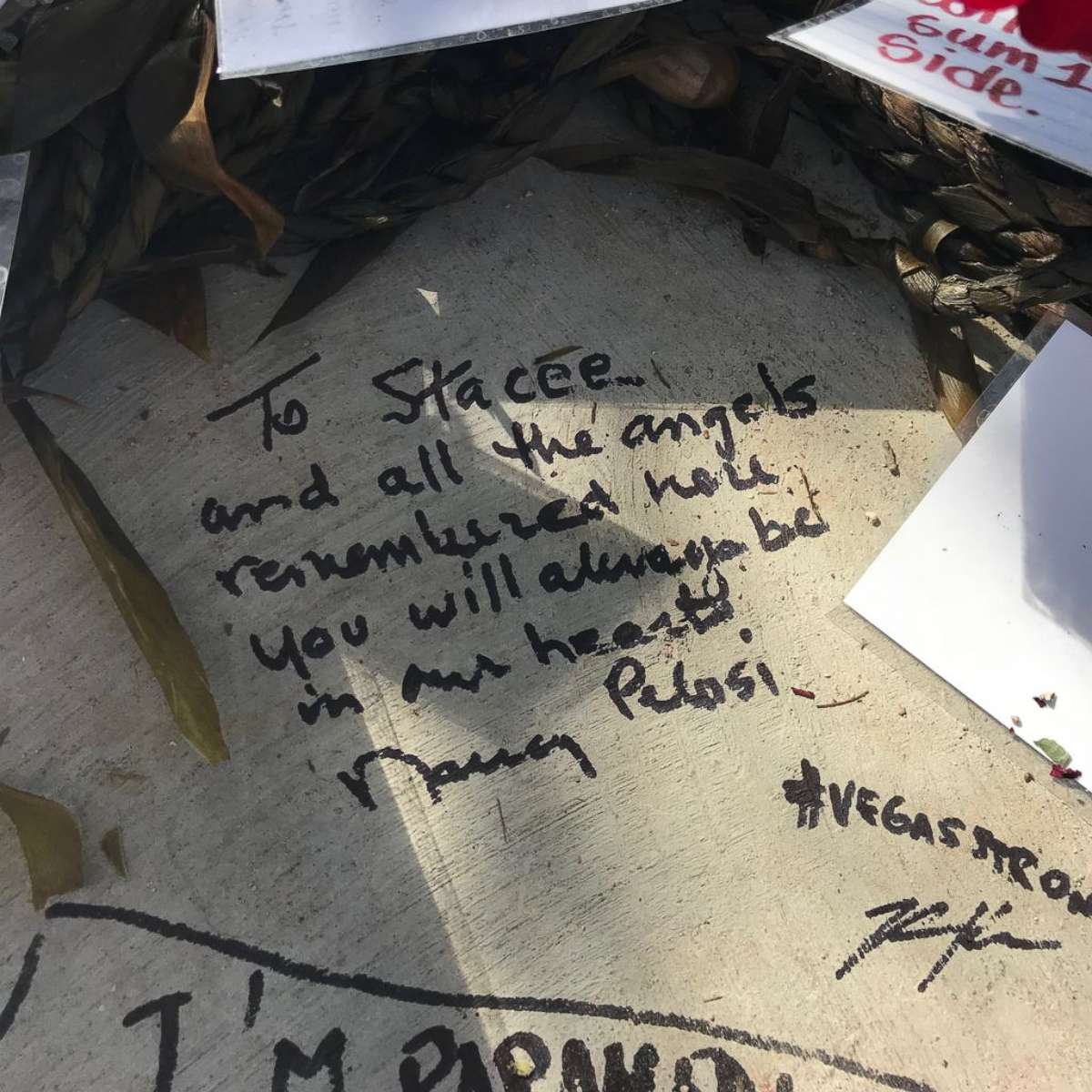 PHOTO: House Minority Leader Nancy Pelosi writes a message to Las Vegas shooting victim Stacee Etcheber at the Las Vegas Community Healing Garden on October 17, 2017.