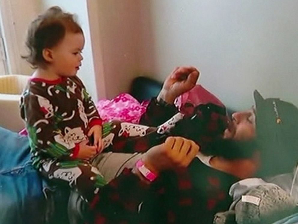 PHOTO: Lily Groesbeck plays with her father, Devin Trafny, in a hospital room on March 11, 2015, in a home video provided by a family member.