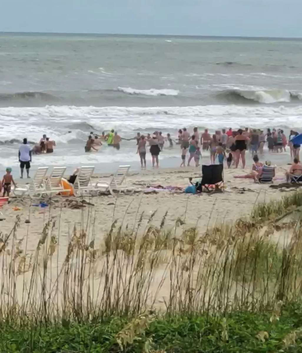 PHOTO: Beach-goers in Emerald Isle, North Carolina, formed a human chain to help get swimmers out of the rough surf.