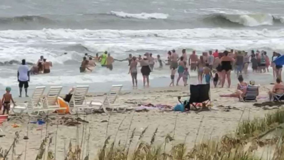 Beach Goers Form Human Chain To Rescue Swimmers From Rough Surf In