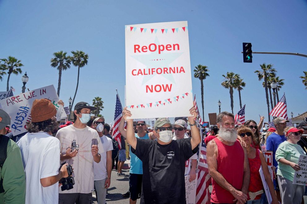 PHOTO: People gather near Huntington Beach Pier to protest Gov. Gavin Newsom's order to temporarily close state and local beaches in Orange County, during the outbreak of the coronavirus virus, in Huntington Beach, California, U.S., May 1, 2020.