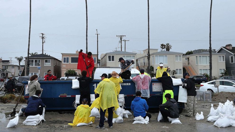 PHOTO: Volunteers and members of the Long Beach Fire Department fill sandbags at Belmont Shore Beach, Aug. 20, 2023 in Long Beach, Calif.