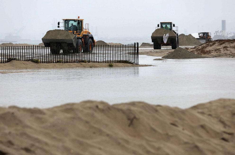 PHOTO: Heavy equipment moves sand to create barriers at Belmont Shore Beach as tropical storm Hilary approaches, Aug. 20, 2023 in Long Beach, Calif.