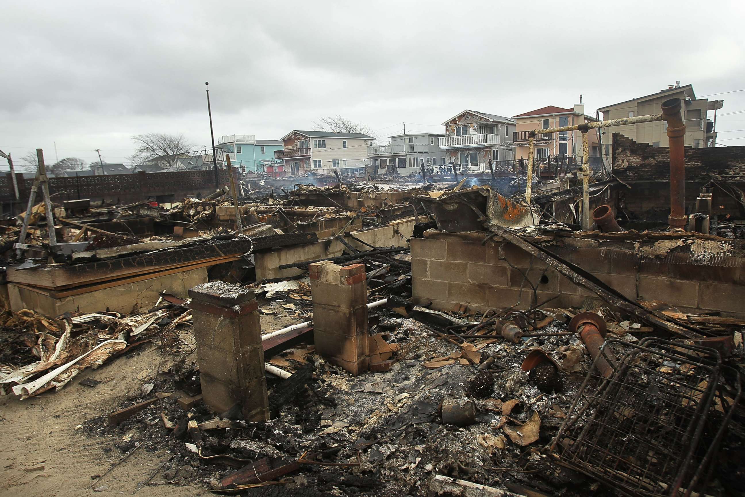 PHOTO: Homes sit smoldering after Hurricane Sandy on Oct. 30, 2012 in the Breezy Point Neighborhood of the Queens borough of New York City.