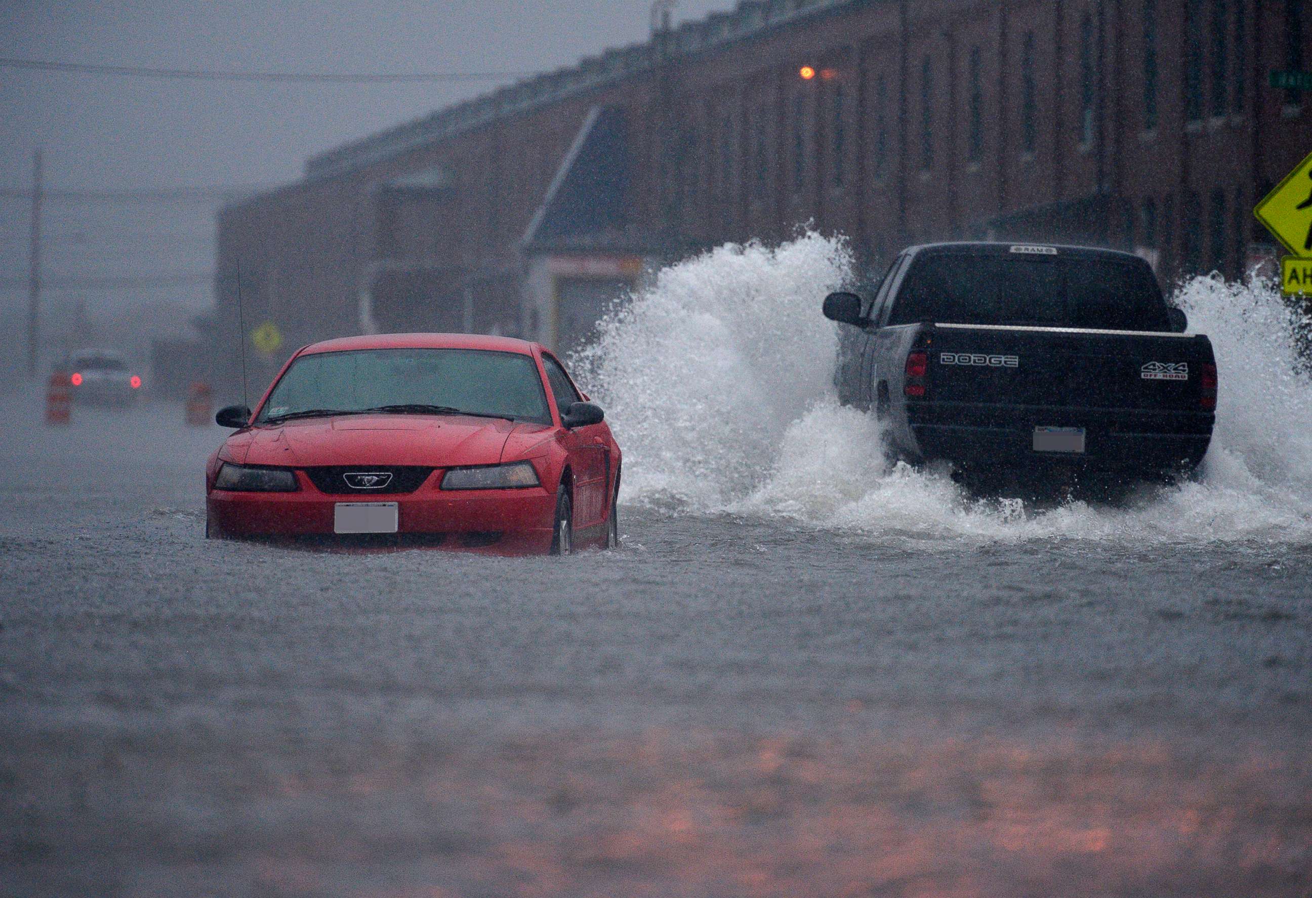 PHOTO: In this July 4, 2014, file photo, a pick-up truck makes its way pass an abandoned car in New Bedford, Mass., which were flooded by the heavy rains brought in by Hurricane Arthur.