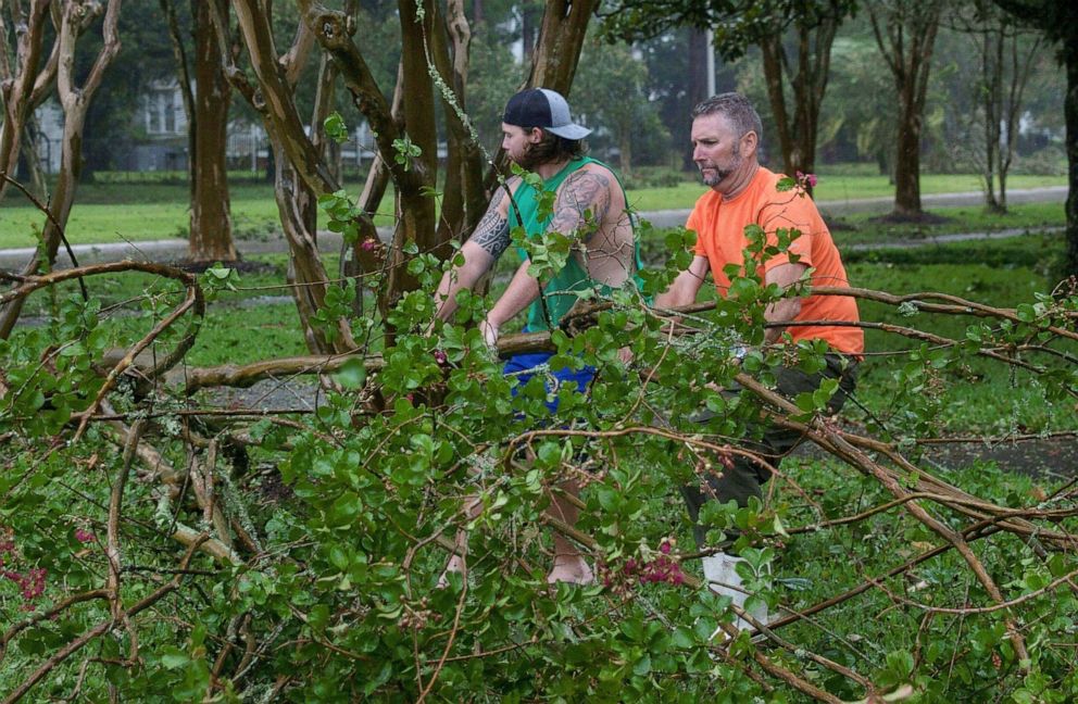 PHOTO: Residents remove a downed tree from a road in Morgan City, La., ahead of Tropical Storm Barry, July 13,2019.