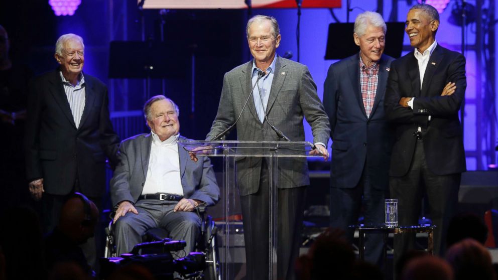 Former President George W. Bush, center, speaks as fellow former Presidents from right, Barack Obama, Bill Clinton, George H.W. Bush and Jimmy Carter look on during a hurricanes relief concert in College Station, Texas, Oct. 21, 2017.