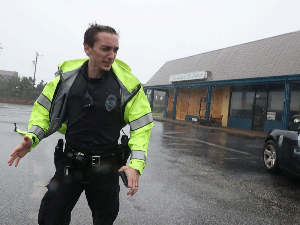 PHOTO: A police officer inspects a shopping center for damage after Hurricane Dorian hit the area, on Sept. 6, 2019 in Nags Head, N.C.