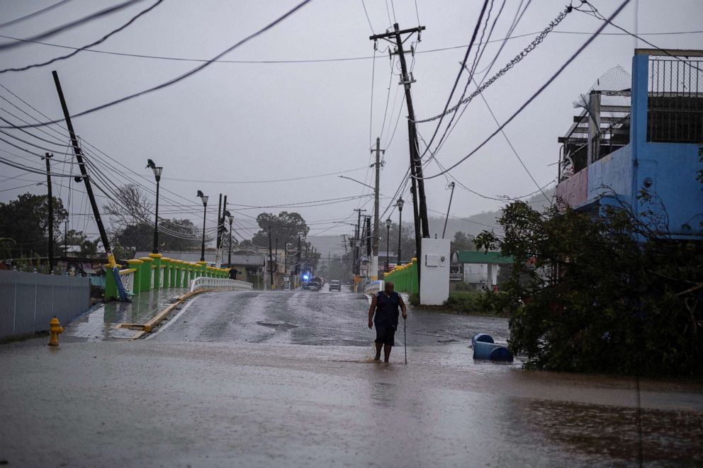 PHOTO: A man wades through a flooded street after Hurricane Fiona affected the area in Yauco, Puerto Rico September 18, 2022. REUTERS/Ricardo Arduengo