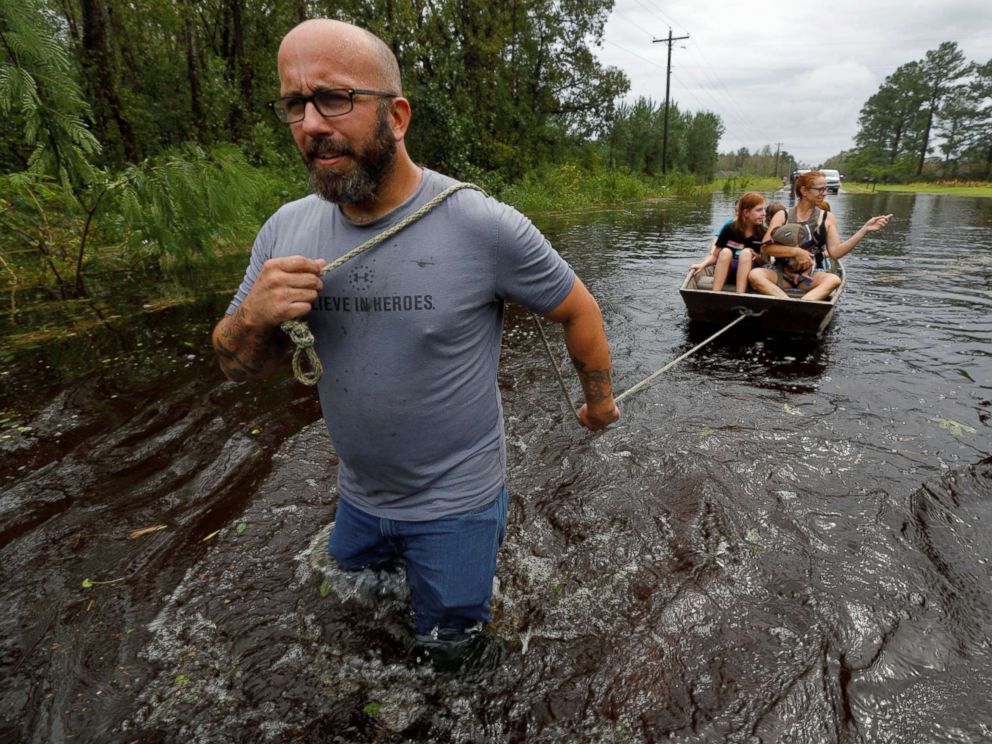 PHOTO: A volunteer from the community pulls a boat holding a mother and her children during their rescue from rising flood waters in the aftermath of Hurricane Florence, in Leland, N.C., Sept. 16, 2018.