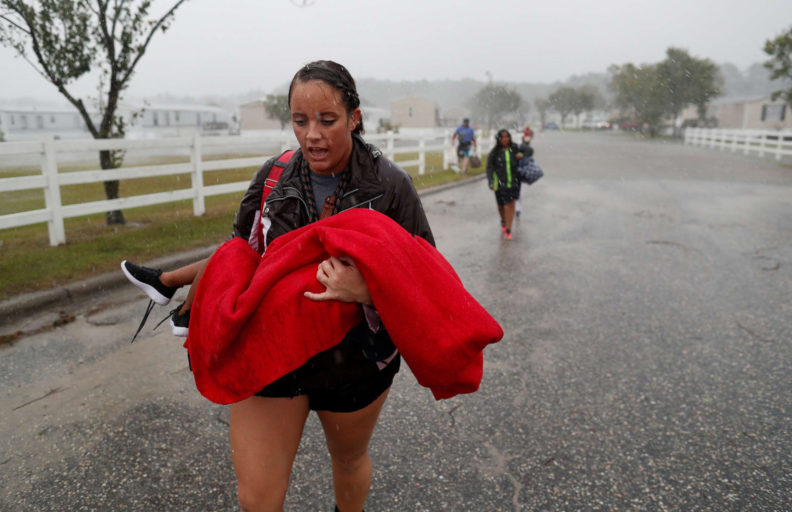 PHOTO: During a driving rain, Maggie Belgie of The Cajun Navy carries a child evacuating a flooding trailer community during Hurricane Florence in Lumberton, N.C., Sept. 15, 2018.