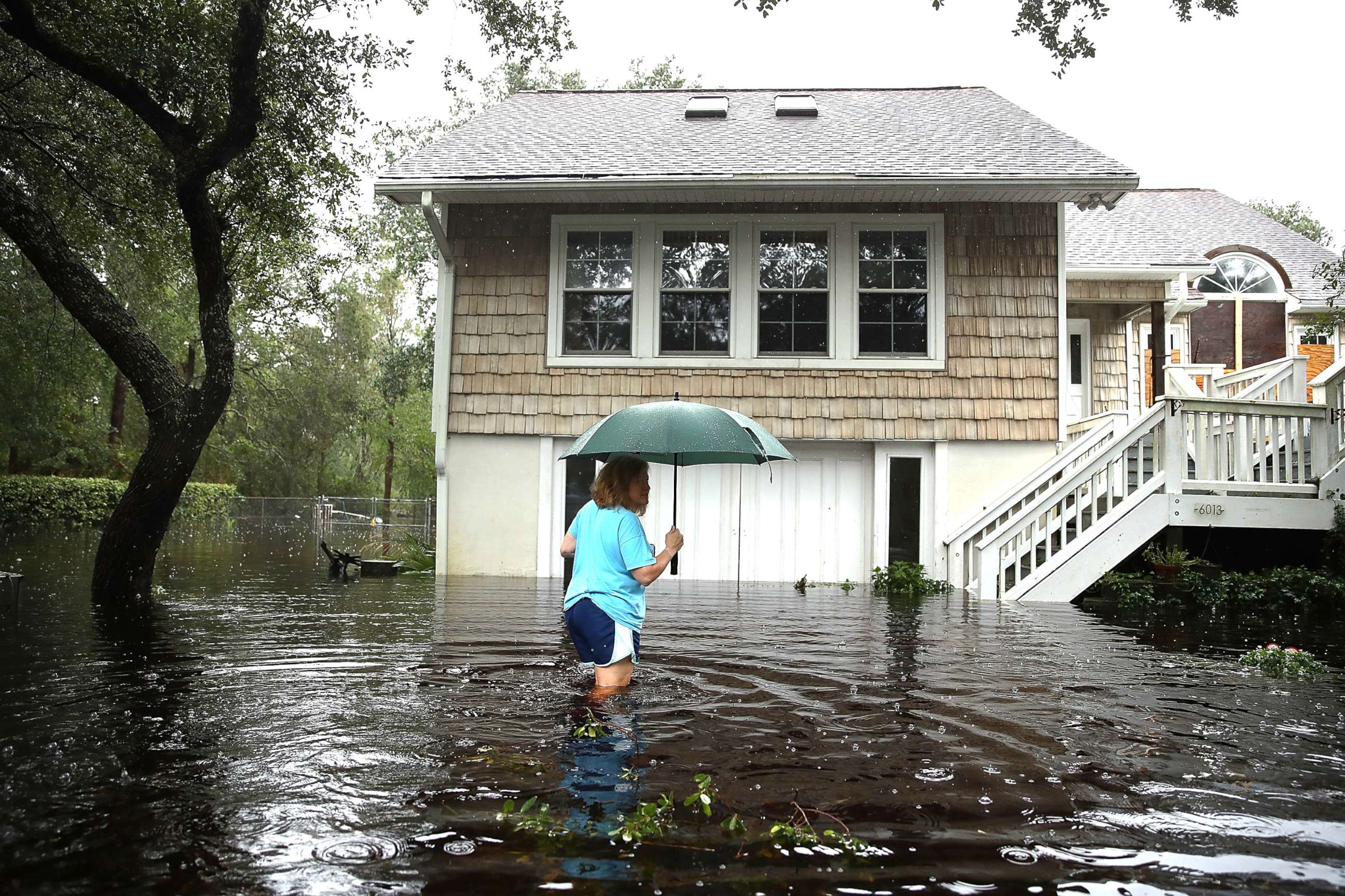PHOTO: A woman makes her way to her home that is surrounded by flood waters after Hurricane Florence passed through the area on Sept. 15, 2018, in Southport, N.C.