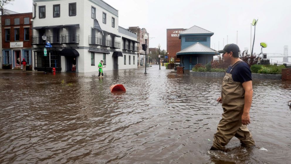 PHOTO: People walk through flooded Water Street as Hurricane Florence comes ashore in Wilmington, N.C., Sept. 14, 2018.