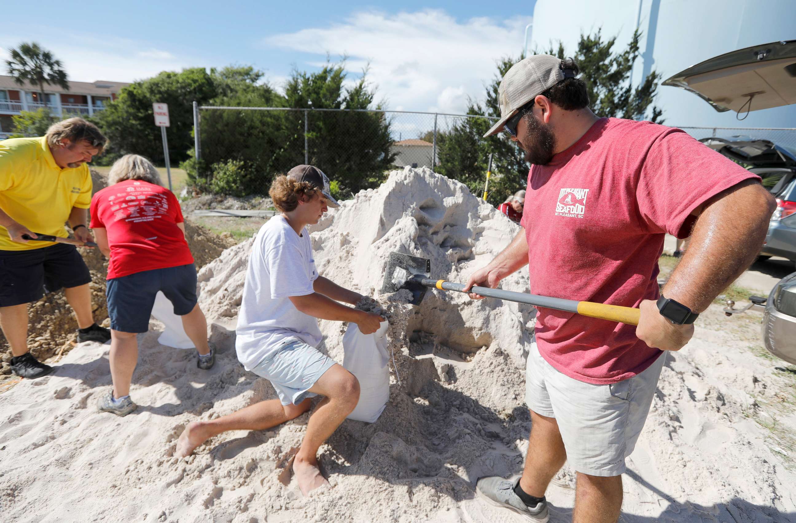 PHOTO: Walker Townsend, right, fills a sand bag while Dalton Trout, center, holds the bag at the Isle of Palms municipal lot where the city was giving away free sand in preparation for Hurricane Florence, Sept. 10, 2018.