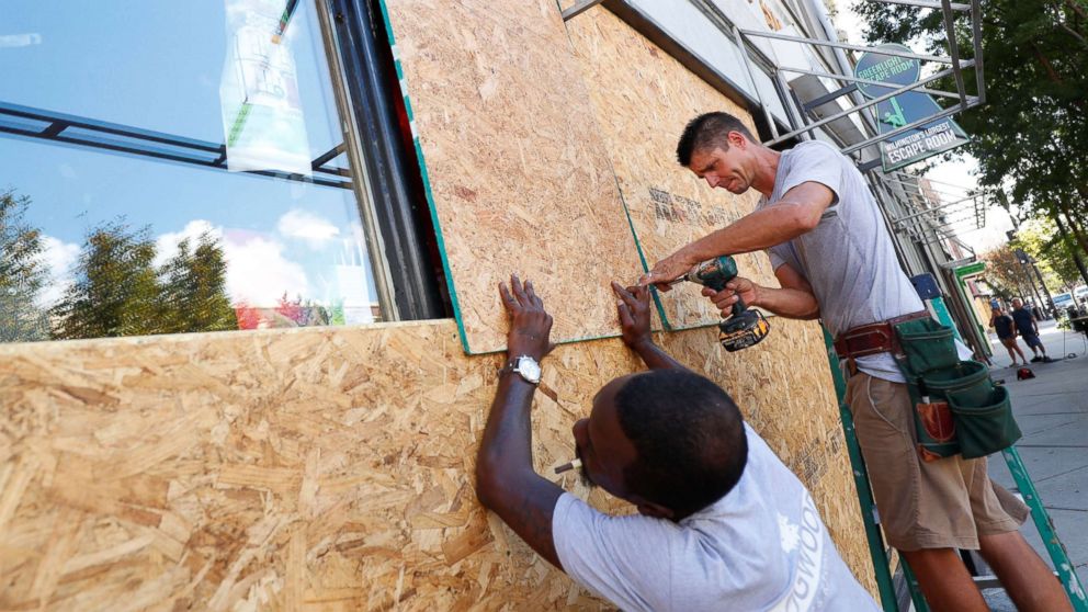 Workers are seen as they work to secure plywood ahead of the arrival of Hurricane Florence in Wilmington, North Carolina, Sept. 12, 2018.