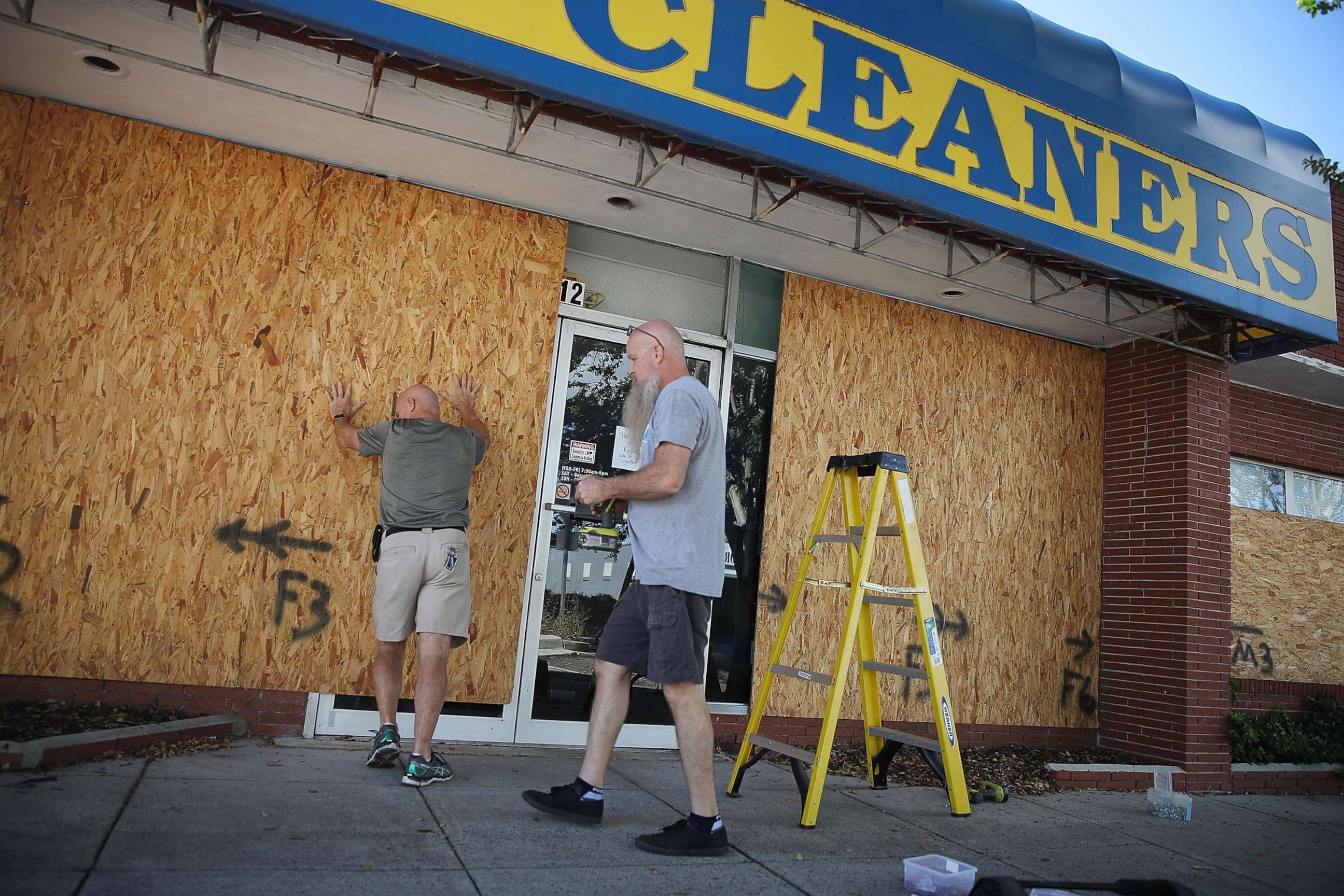 PHOTO: Michael Schwartz (L) and Jay Schwartz secure plywood over the windows of their business ahead of the arrival of Hurricane Florence, Sept. 11, 2018, in Myrtle Beach, S.C.