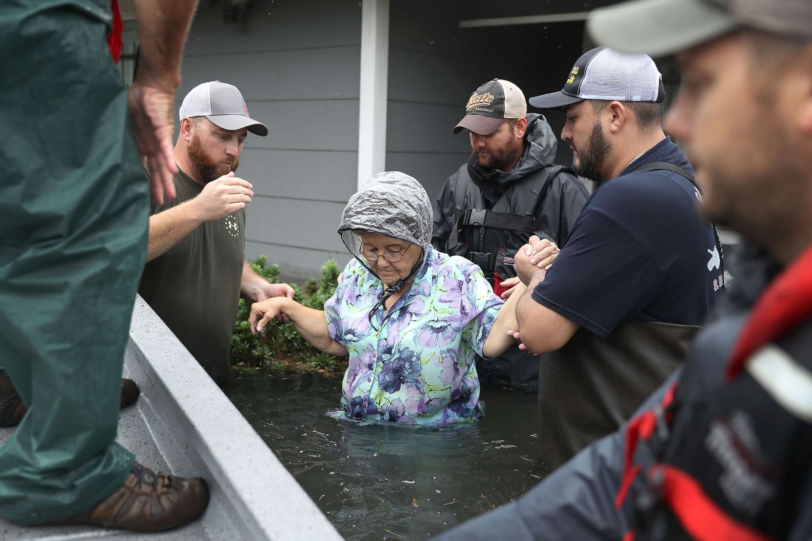 PHOTO: Volunteer rescuer workers help a woman from her home that was inundated with the flooding of Hurricane Harvey, Aug. 30, 2017 in Port Arthur, Texas.
