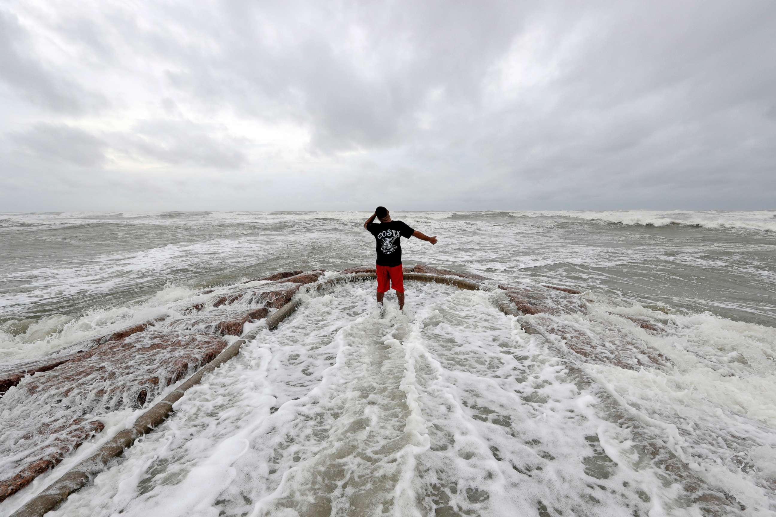PHOTO: Luis Perez watches waves crash against a jetty in Galveston, Texas as Hurricane Harvey intensifies in the Gulf of Mexico, Aug. 25, 2017.