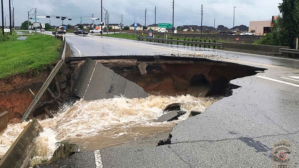 PHOTO: Water rushes from a large sinkhole on Highway FM 762 in Rosenberg, Tx., near Houston, on Aug. 27, 2017. 