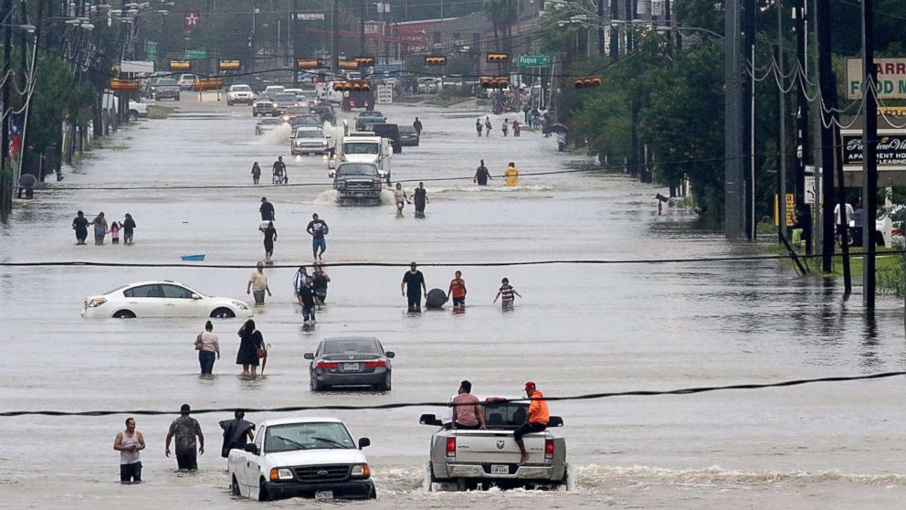 PHOTO: People walk through the flooded waters of Telephone Rd. in Houston on Aug. 27, 2017, as the city battles with tropical storm Harvey and resulting floods.