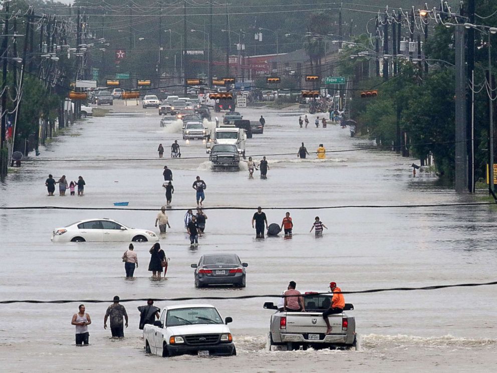PHOTO: People walk through the flooded waters of Telephone Rd. in Houston on Aug. 27, 2017, as the city battles with tropical storm Harvey and resulting floods.