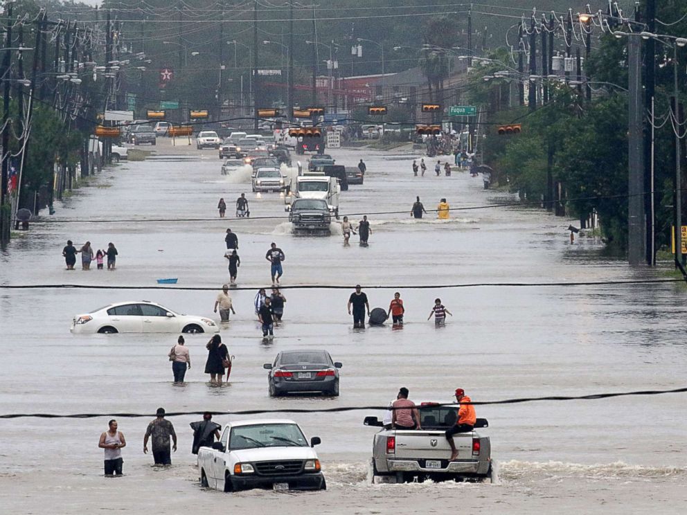 PHOTO: People walk through the flooded waters of Telephone Rd. in Houston on Aug. 27, 2017, as the city battles with tropical storm Harvey and resulting floods.